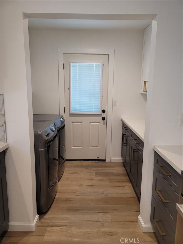 6091 Larchwood Dr, Huntington Beach, CA 92647 - laundry area featuring cabinet space, washing machine and dryer, and light wood-type flooring