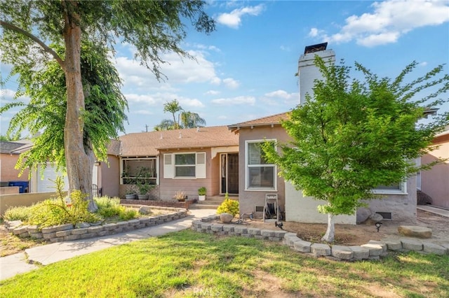 315 E Clinton Ave, Fresno, CA 93704 - view of front of property with a front lawn, stucco siding, and a chimney
