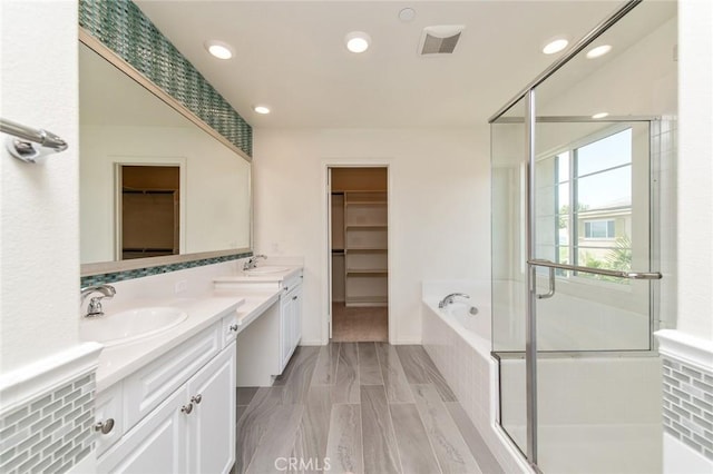 13246 Baxter Springs Dr, Rancho Cucamonga, CA 91739 - full bathroom featuring double vanity, a walk in closet, a bath, a stall shower, and recessed lighting