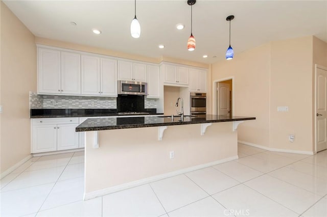 13246 Baxter Springs Dr, Rancho Cucamonga, CA 91739 - kitchen with appliances with stainless steel finishes, decorative backsplash, a spacious island, a kitchen bar, and white cabinetry