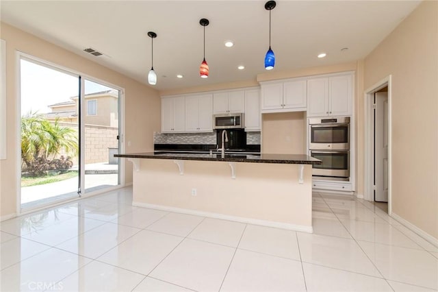 13246 Baxter Springs Dr, Rancho Cucamonga, CA 91739 - kitchen featuring appliances with stainless steel finishes, backsplash, white cabinets, a kitchen breakfast bar, and recessed lighting