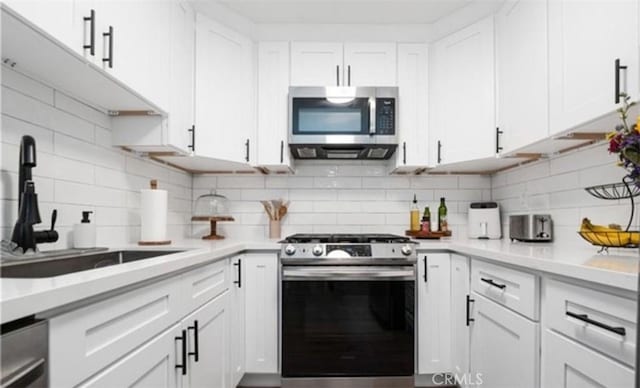 9525 Sylmar Ave Unit 2, Panorama City, CA 91402 - kitchen featuring appliances with stainless steel finishes, white cabinets, and decorative backsplash