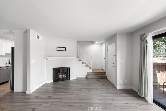 9525 Sylmar Ave Unit 2, Panorama City, CA 91402 - entrance foyer featuring light wood-style floors, a warm lit fireplace, and stairway