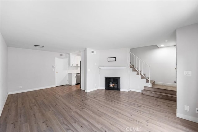 9525 Sylmar Ave Unit 2, Panorama City, CA 91402 - unfurnished living room featuring a fireplace, wood finished floors, and stairs
