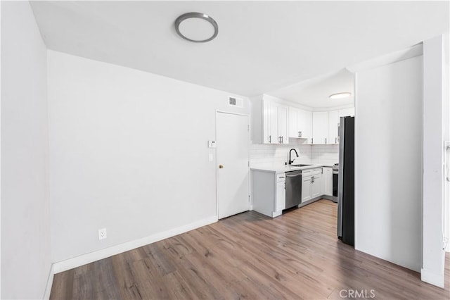 9525 Sylmar Ave Unit 2, Panorama City, CA 91402 - kitchen with stainless steel dishwasher, wood finished floors, light countertops, and white cabinets
