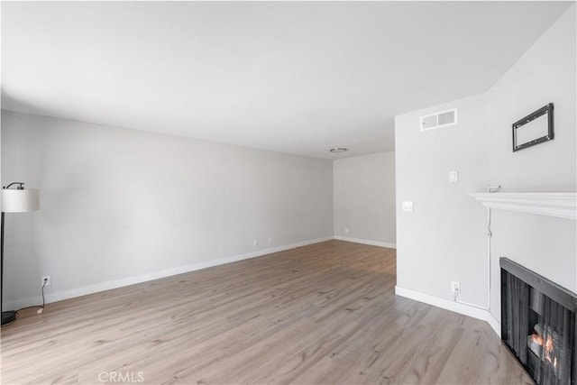 9525 Sylmar Ave Unit 2, Panorama City, CA 91402 - unfurnished living room with a warm lit fireplace and light wood finished floors