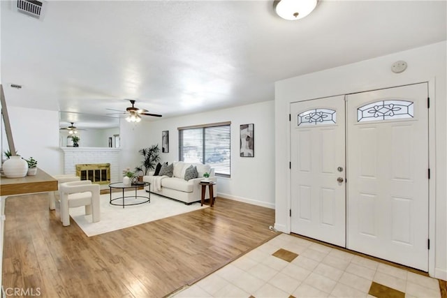 27218 Monk St, Menifee, CA 92586 - foyer entrance with ceiling fan, light wood-style floors, and a brick fireplace