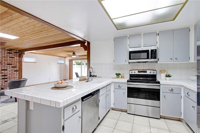 27218 Monk St, Menifee, CA 92586 - kitchen with stainless steel appliances, a peninsula, a ceiling fan, decorative backsplash, and wooden ceiling