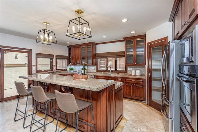 624 S Reese Pl, Burbank, CA 91506 - kitchen featuring stainless steel appliances, tasteful backsplash, recessed lighting, a kitchen bar, and decorative light fixtures