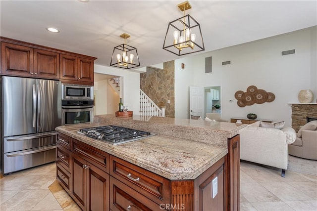 624 S Reese Pl, Burbank, CA 91506 - kitchen with appliances with stainless steel finishes, open floor plan, a chandelier, light tile patterned floors, and light stone countertops