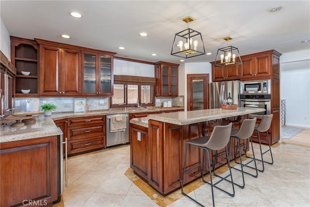624 S Reese Pl, Burbank, CA 91506 - kitchen with appliances with stainless steel finishes, a center island, tasteful backsplash, recessed lighting, and light stone countertops