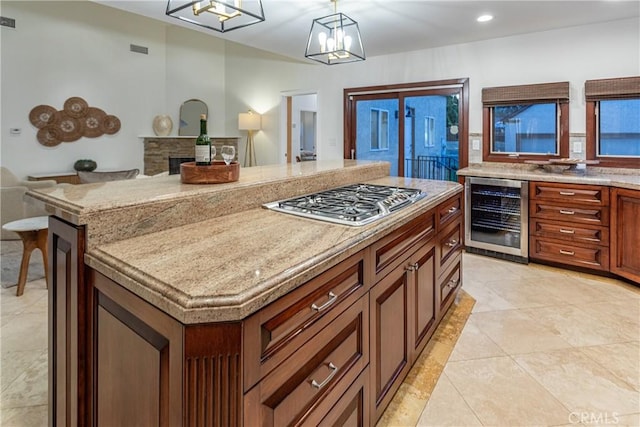 624 S Reese Pl, Burbank, CA 91506 - kitchen with beverage cooler, stainless steel gas cooktop, light tile patterned floors, a center island, and decorative light fixtures
