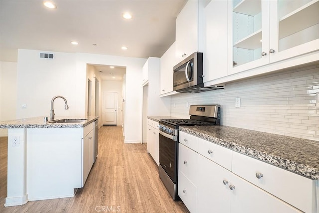 12893 Breccia Way, Moreno Valley, CA 92555 - kitchen with stainless steel appliances, light wood-style floors, white cabinetry, stone countertops, and recessed lighting