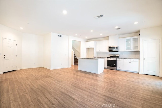 12893 Breccia Way, Moreno Valley, CA 92555 - kitchen with stainless steel appliances, light wood-type flooring, white cabinets, recessed lighting, and open floor plan