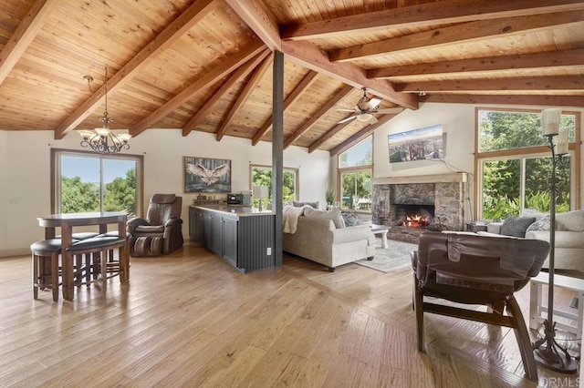 15935 Mac Tan Ln, Valley Center, CA 92082 - living room featuring light wood-type flooring, a stone fireplace, a chandelier, ceiling fan, and a wood ceiling with exposed beams