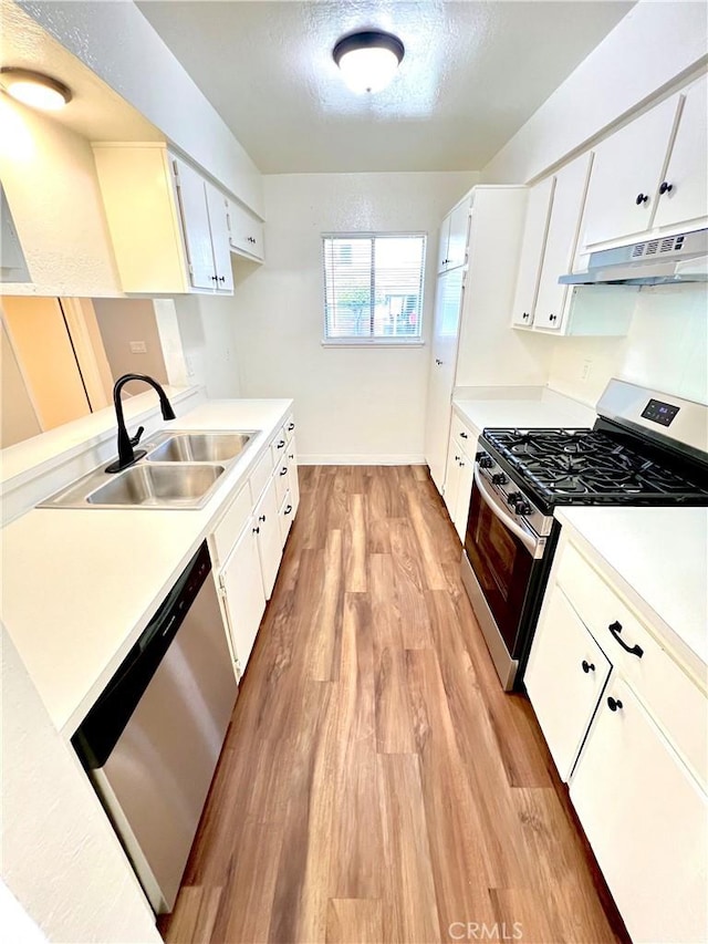 13895 Parkway Dr Unit 79, Garden Grove, CA 92843 - kitchen featuring stainless steel appliances, light wood-style flooring, under cabinet range hood, light countertops, and white cabinetry