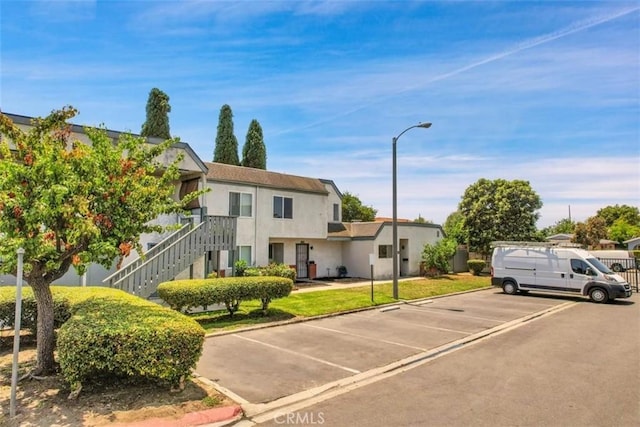 13895 Parkway Dr Unit 79, Garden Grove, CA 92843 - view of front of property featuring uncovered parking, stairway, and stucco siding