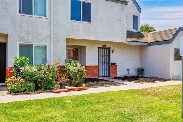 13895 Parkway Dr Unit 79, Garden Grove, CA 92843 - doorway to property with stucco siding and a lawn