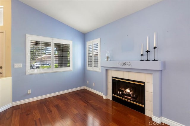 23998 Via Astuto, Murrieta, CA 92562 - unfurnished living room featuring wood finished floors, vaulted ceiling, and a tiled fireplace