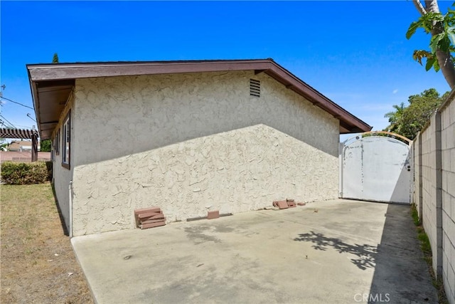 6433 San Marcos Way, Buena Park, CA 90620 - view of side of property with stucco siding, a patio, and a gate