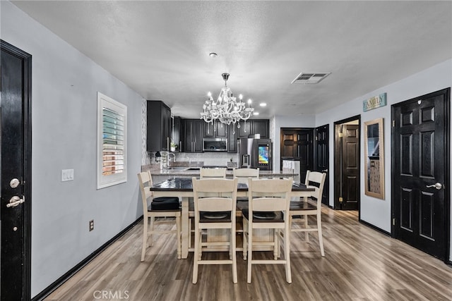 26120 Goldman Pl, Saugus, CA 91350 - dining room featuring a chandelier and light wood-type flooring