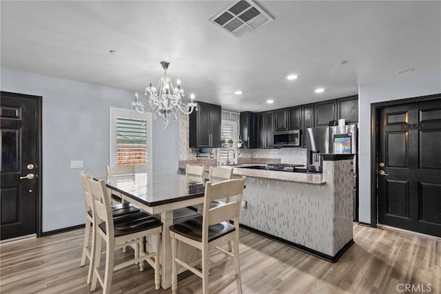 26120 Goldman Pl, Saugus, CA 91350 - dining space with a chandelier, light wood-style floors, and recessed lighting