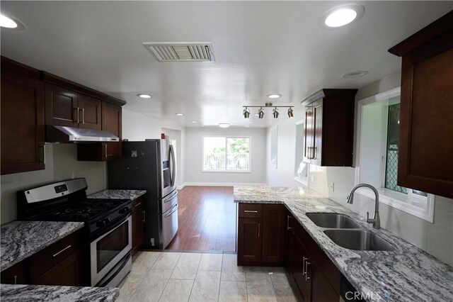 7712 Young Ave, Rosemead, CA 91770 - kitchen with appliances with stainless steel finishes, under cabinet range hood, light stone counters, dark brown cabinets, and recessed lighting
