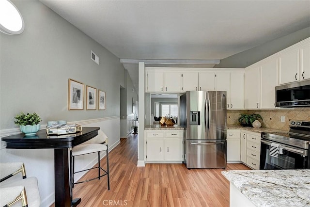 21812 Raintree Ln, Lake Forest, CA 92630 - kitchen featuring stainless steel appliances, tasteful backsplash, white cabinetry, and light wood-style floors