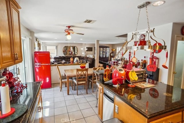 29720 Creekbed Rd, Castaic, CA 91384 - kitchen featuring ceiling fan, brown cabinets, light tile patterned floors, refrigerator, and dark stone counters