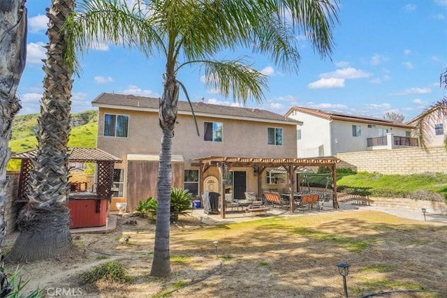 29720 Creekbed Rd, Castaic, CA 91384 - rear view of house featuring a hot tub, a pergola, stucco siding, and a patio