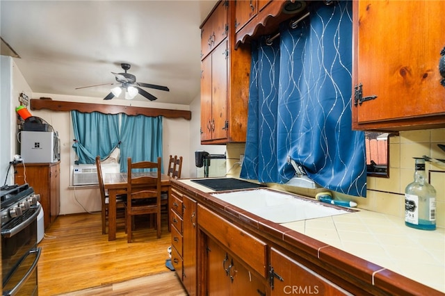 950 E Yale St, Ontario, CA 91764 - kitchen with tile countertops, range with two ovens, a ceiling fan, light wood finished floors, and brown cabinetry