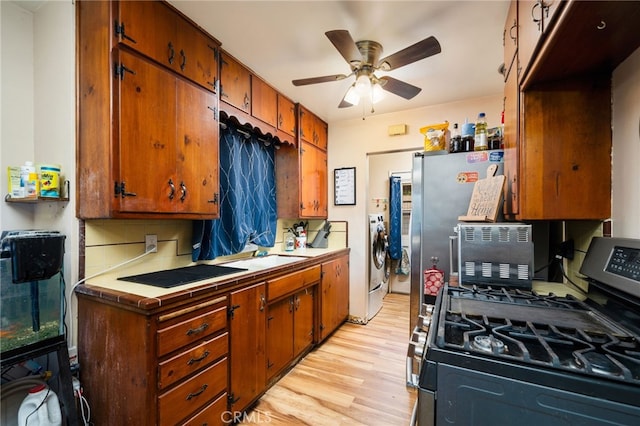 950 E Yale St, Ontario, CA 91764 - kitchen with gas range, tile countertops, light wood finished floors, ceiling fan, and washing machine and dryer