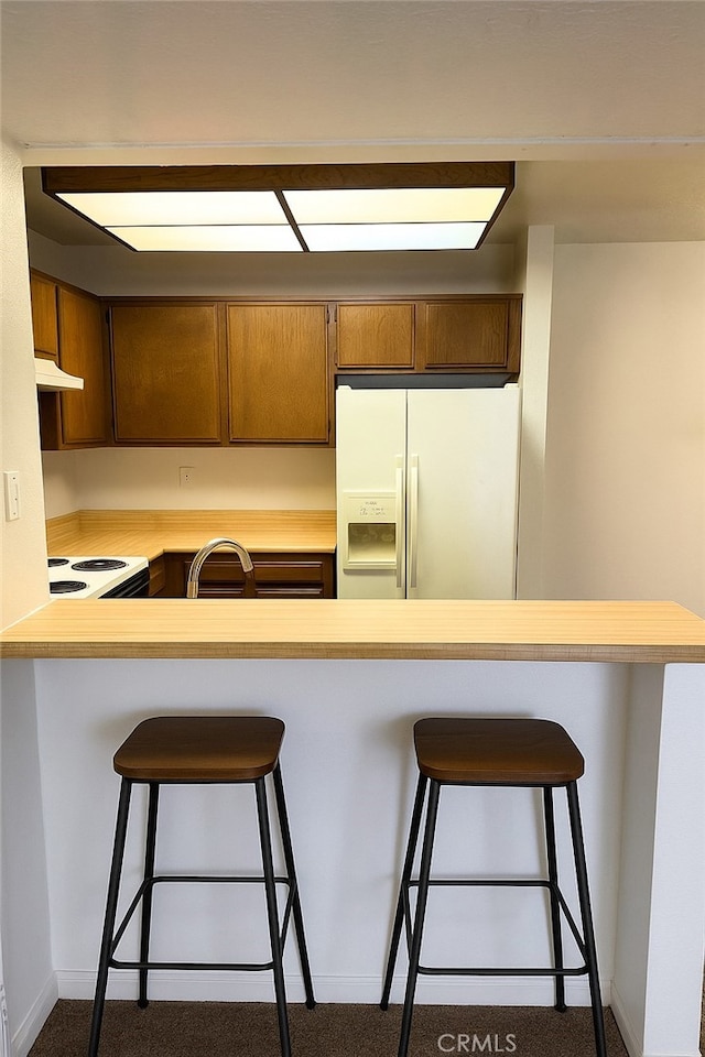 1480 W Edgehill Rd Unit 58, San Bernardino, CA 92405 - kitchen featuring white appliances, dark carpet, under cabinet range hood, and light countertops
