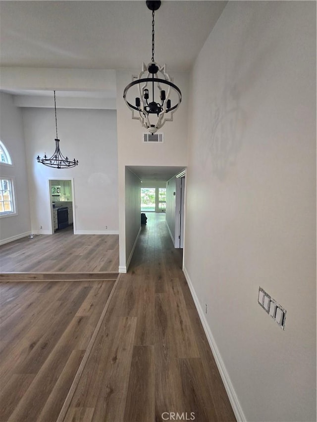 10281 Kings St, Los Alamitos, CA 90720 - unfurnished dining area with a chandelier, healthy amount of natural light, dark wood-style floors, and a high ceiling