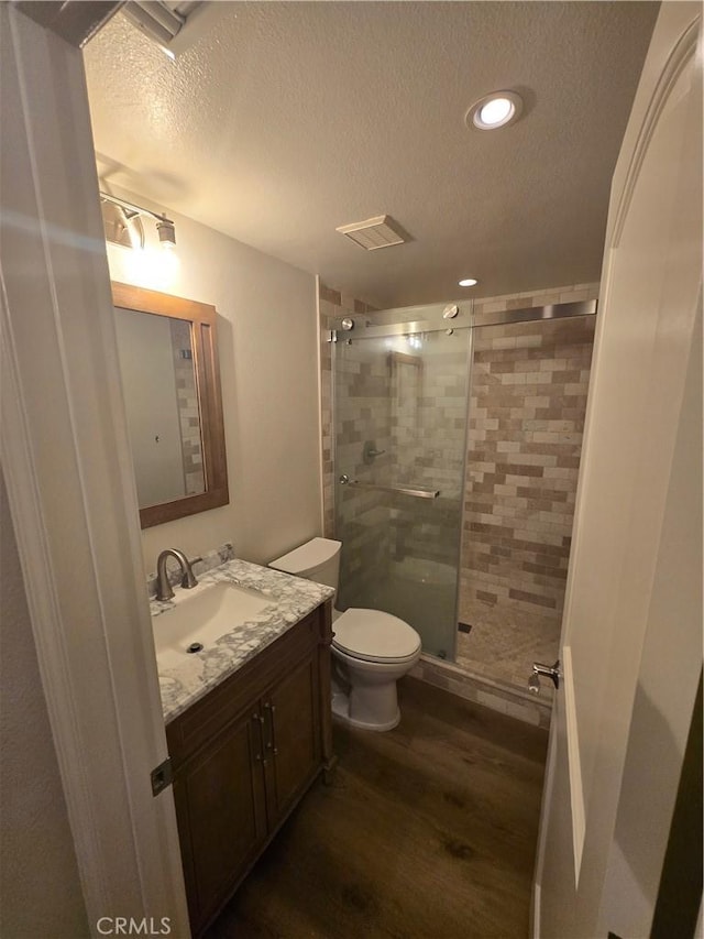 10281 Kings St, Los Alamitos, CA 90720 - bathroom featuring a textured ceiling, wood finished floors, vanity, a shower stall, and recessed lighting