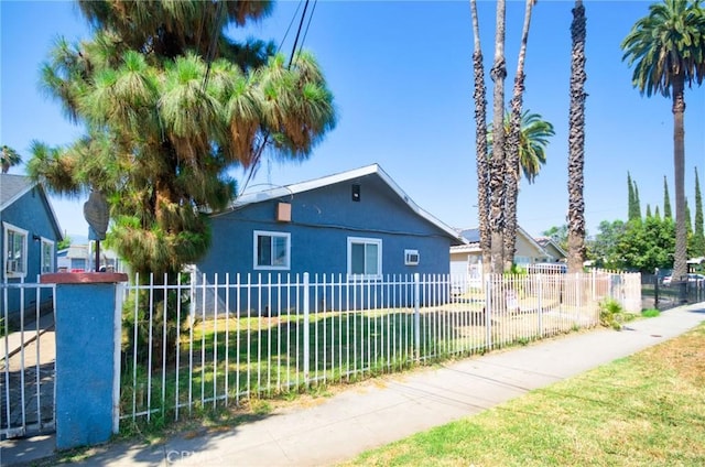 188 E 11th St Unit 1-4, San Bernardino, CA 92410 - view of side of home with stucco siding and a fenced front yard