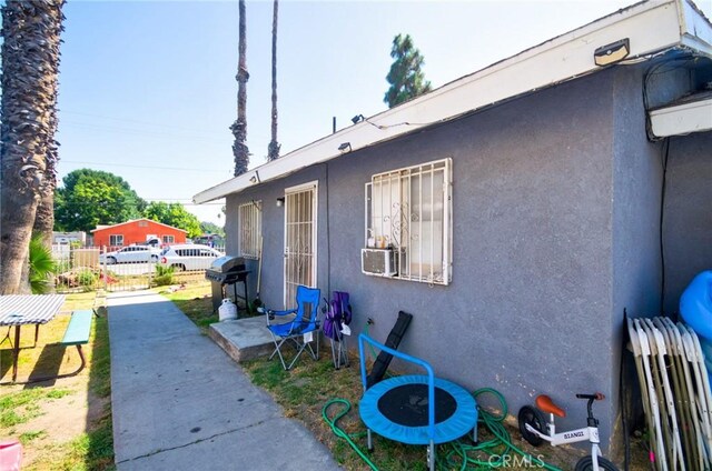 188 E 11th St Unit 1-4, San Bernardino, CA 92410 - view of side of property with stucco siding and cooling unit