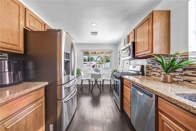 17106 Donmetz St, Granada Hills, CA 91344 - kitchen with stainless steel appliances, brown cabinets, light stone counters, tasteful backsplash, and recessed lighting
