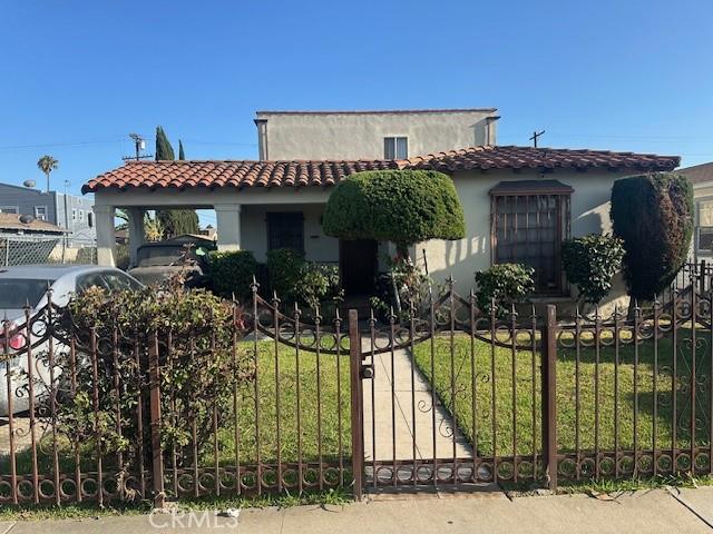 844 W 74th St, Los Angeles, CA 90044 - mediterranean / spanish-style house featuring stucco siding, a gate, and a tile roof
