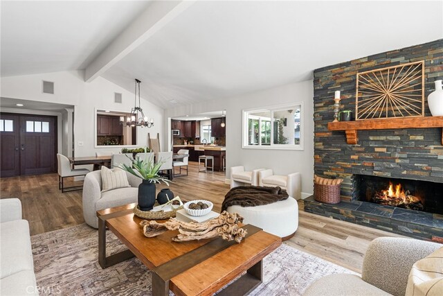 11212 Brunswick Way N, Tustin, CA 92705 - living room featuring wood finished floors, a chandelier, a fireplace, and healthy amount of natural light