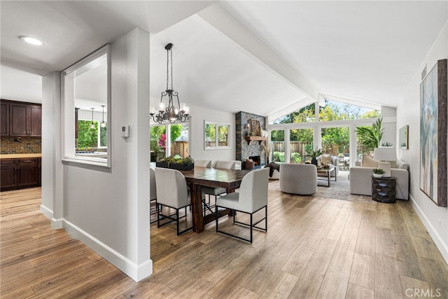 11212 Brunswick Way N, Tustin, CA 92705 - dining space with light wood-style flooring, a fireplace, and a chandelier