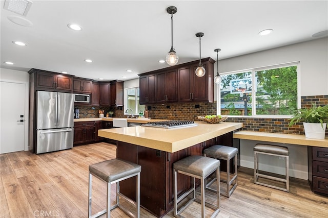 11212 Brunswick Way N, Tustin, CA 92705 - kitchen featuring stainless steel appliances, dark brown cabinets, light countertops, light wood-style floors, and recessed lighting