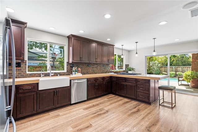 11212 Brunswick Way N, Tustin, CA 92705 - kitchen featuring dishwasher, light countertops, a peninsula, dark brown cabinets, and backsplash