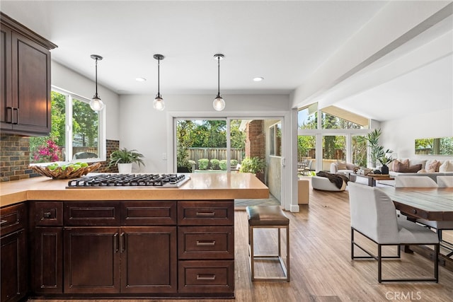 11212 Brunswick Way N, Tustin, CA 92705 - kitchen featuring stainless steel gas cooktop, dark brown cabinetry, a peninsula, light countertops, and light wood-type flooring