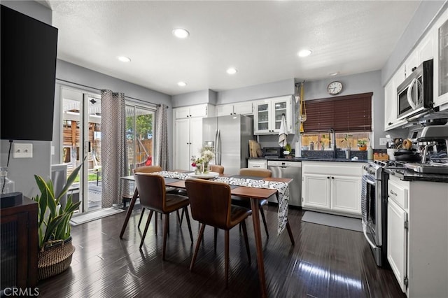 943 Miraflores Dr, Corona, CA 92882 - kitchen featuring stainless steel appliances, dark countertops, white cabinets, glass insert cabinets, and recessed lighting
