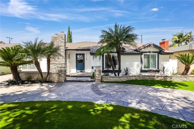 2134 N Towner St, Santa Ana, CA 92706 - view of front of house featuring stucco siding, a chimney, a tile roof, and stone siding