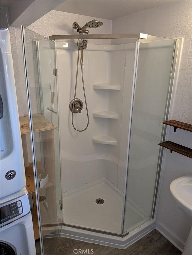 4020 F St, Eureka, CA 95503 - full bath featuring estacked washer and dryer, a shower stall, and wood finished floors