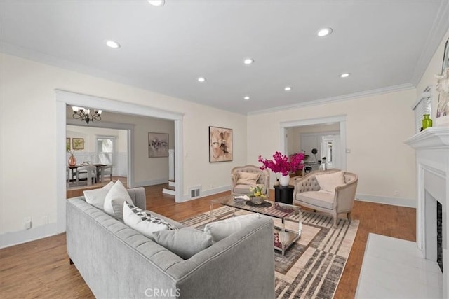268 S Norton Ave, Los Angeles, CA 90004 - living room with a chandelier, a fireplace with flush hearth, wood finished floors, crown molding, and recessed lighting