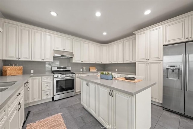 268 S Norton Ave, Los Angeles, CA 90004 - kitchen with stainless steel appliances, under cabinet range hood, light tile patterned flooring, a center island, and light countertops