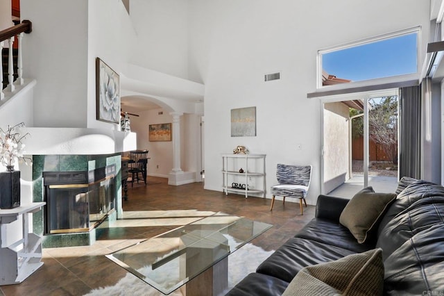 1837 Avenida Sevilla, Oceanside, CA 92056 - living room with ornate columns, arched walkways, a high ceiling, a multi sided fireplace, and stone finish floors